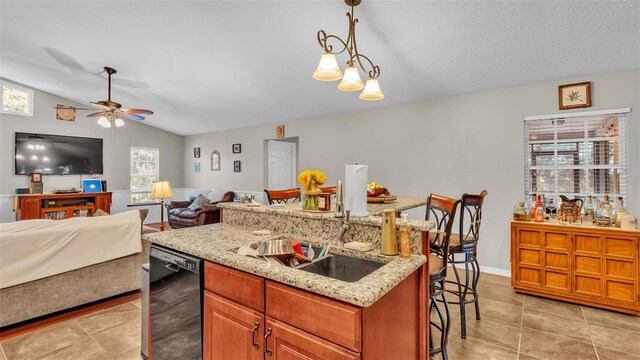 kitchen with dishwasher, sink, plenty of natural light, decorative light fixtures, and a kitchen bar