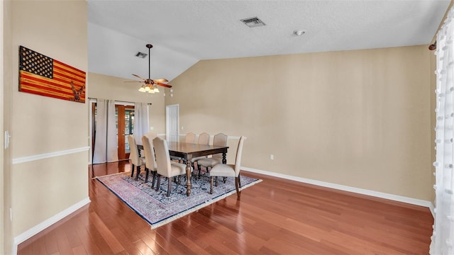 dining area with ceiling fan, lofted ceiling, and hardwood / wood-style flooring