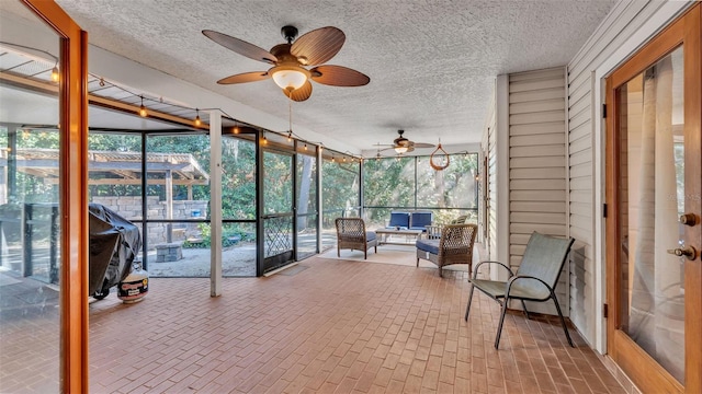 sunroom / solarium featuring ceiling fan