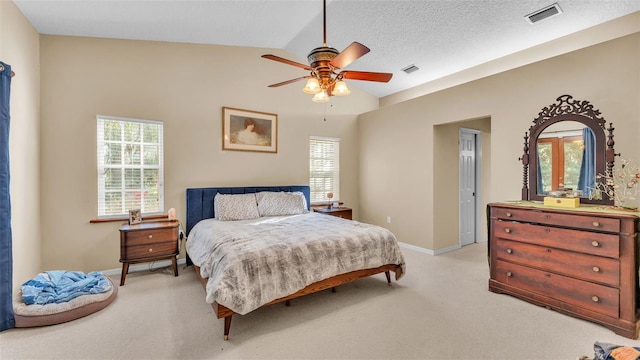 carpeted bedroom featuring a textured ceiling, multiple windows, ceiling fan, and lofted ceiling