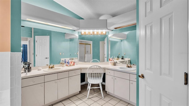 bathroom featuring tile patterned floors, vanity, a textured ceiling, and vaulted ceiling