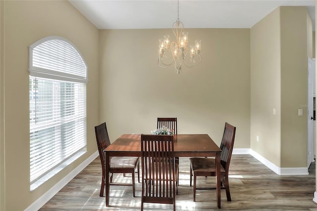 dining area with a wealth of natural light, hardwood / wood-style floors, and a chandelier