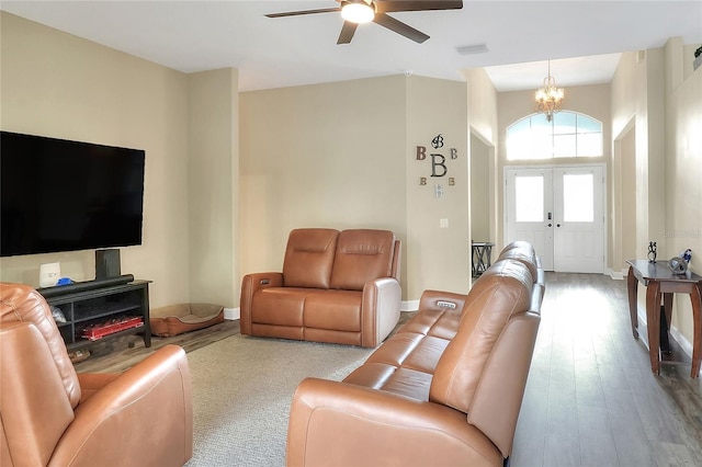 living room featuring french doors, light hardwood / wood-style floors, and ceiling fan with notable chandelier