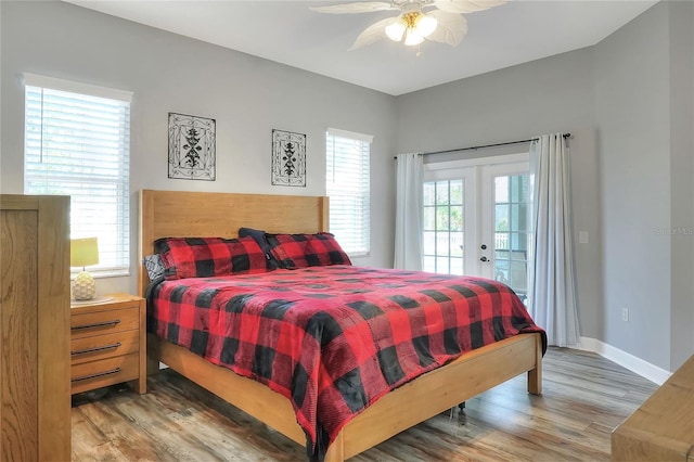 bedroom featuring access to outside, multiple windows, ceiling fan, and hardwood / wood-style flooring