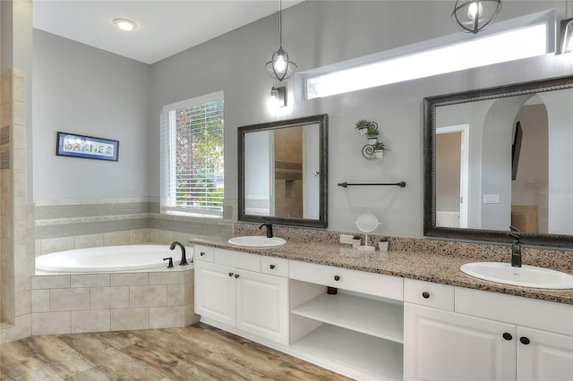 bathroom featuring vanity and tiled tub