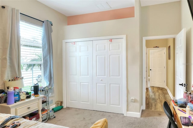 carpeted bedroom featuring multiple windows and a closet