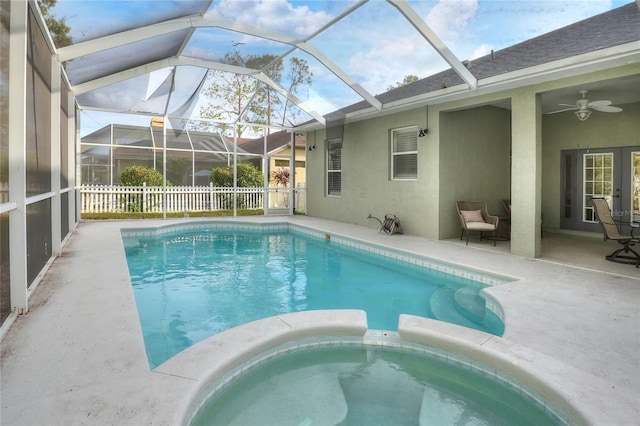 view of swimming pool with ceiling fan, a lanai, an in ground hot tub, and a patio