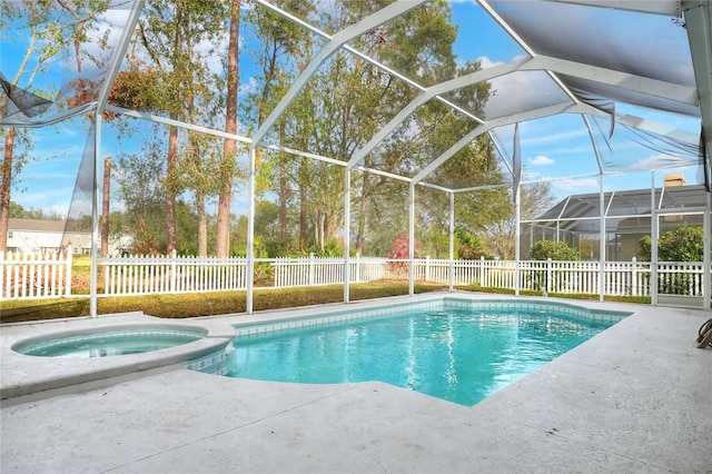 view of swimming pool with glass enclosure, an in ground hot tub, and a patio area