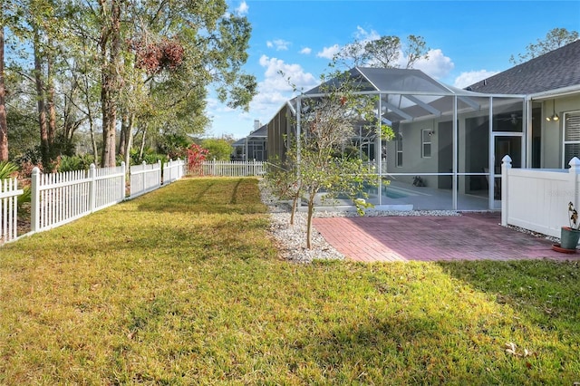 view of yard with glass enclosure and a patio area