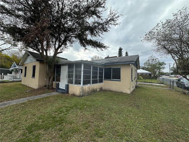 back of house featuring a yard and a sunroom