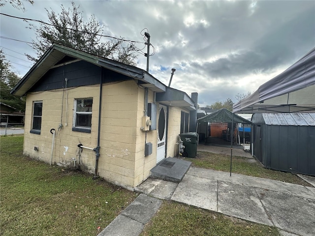 view of property exterior featuring a yard and a storage shed