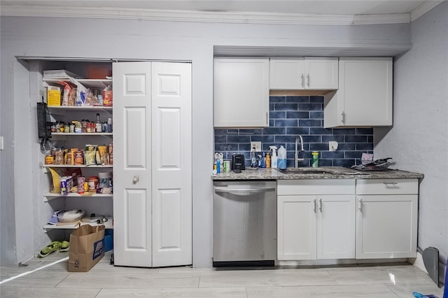 kitchen featuring dark stone counters, white cabinets, sink, stainless steel dishwasher, and tasteful backsplash