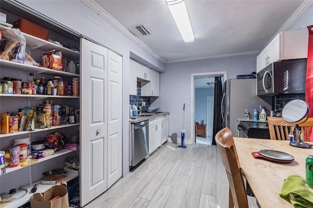 kitchen featuring white cabinets, sink, stainless steel appliances, and light hardwood / wood-style flooring