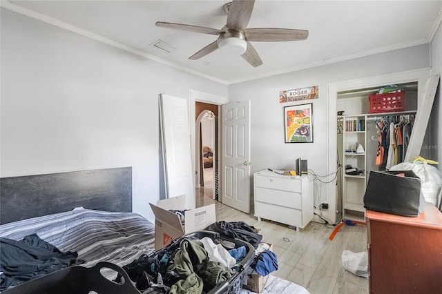 bedroom with light wood-type flooring, a closet, ceiling fan, and crown molding