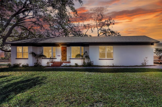 ranch-style home featuring a lawn