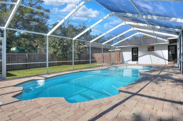 view of swimming pool with a yard, glass enclosure, and a patio area