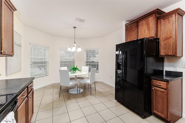 kitchen with light tile patterned flooring, black appliances, hanging light fixtures, and a notable chandelier