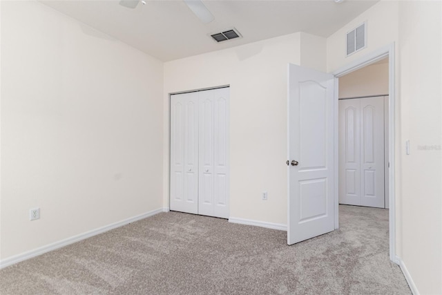 unfurnished bedroom featuring ceiling fan, a closet, and light carpet