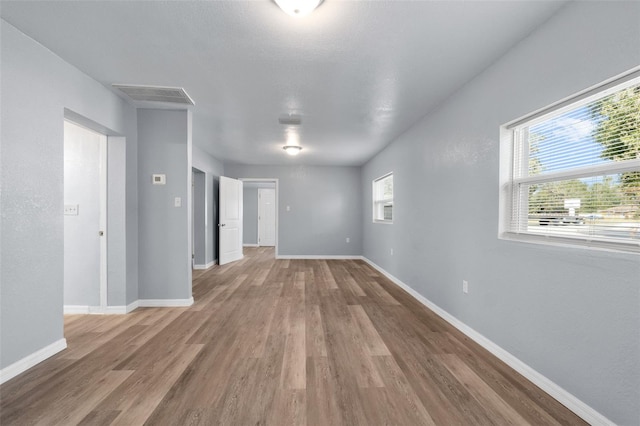 empty room with wood-type flooring and plenty of natural light