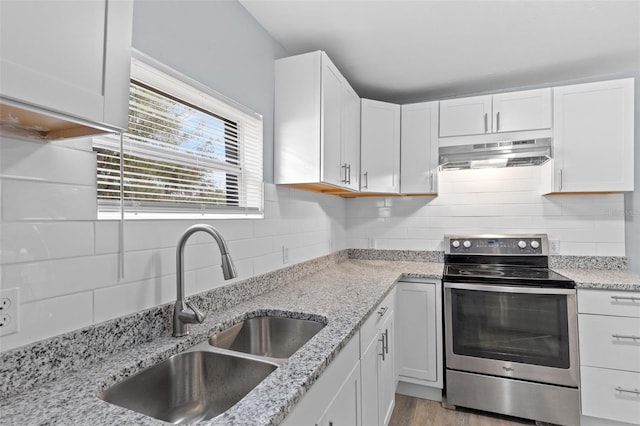 kitchen featuring stainless steel electric stove, white cabinets, and sink