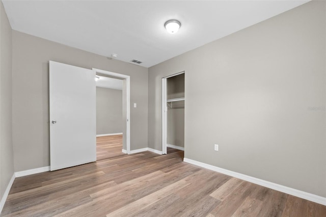 unfurnished bedroom with light hardwood / wood-style floors and a closet