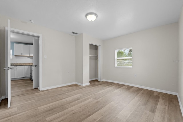 unfurnished bedroom featuring light hardwood / wood-style floors and a closet