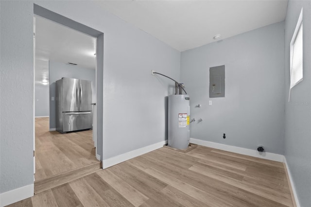 washroom with light hardwood / wood-style flooring, electric panel, and water heater