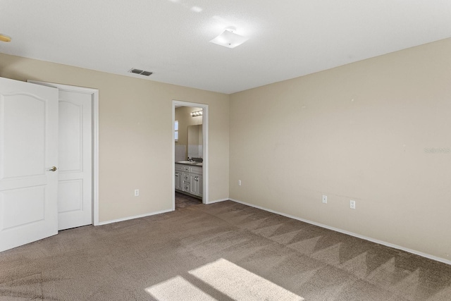 unfurnished bedroom featuring carpet, connected bathroom, and a closet