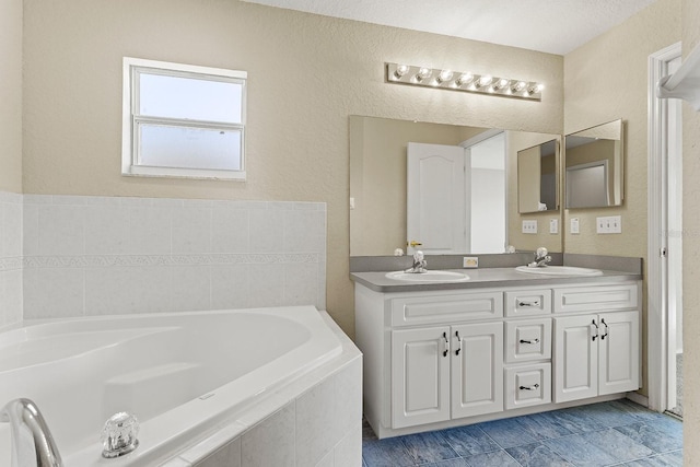 bathroom with vanity and tiled tub