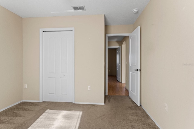 unfurnished bedroom with a closet and carpet floors