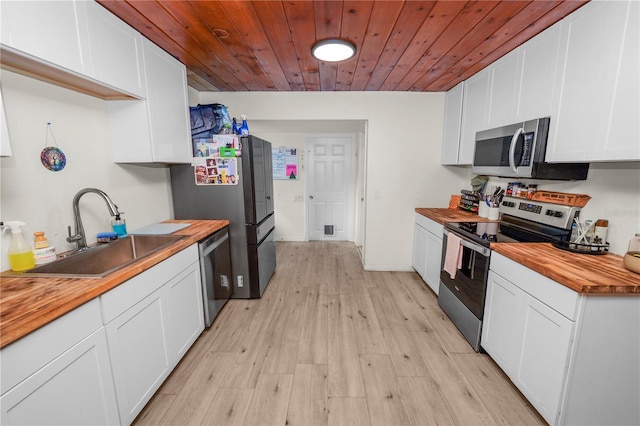 210 Wilder Rd, Lakeland, FL 33809 - kitchen with sink, stainless steel appliances, wood counters, light hardwood / wood-style flooring, and white cabinets