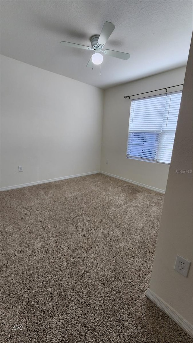 carpeted spare room with ceiling fan