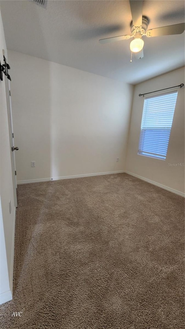 spare room featuring carpet and ceiling fan