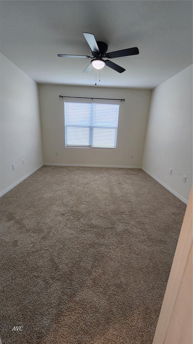 carpeted empty room featuring ceiling fan