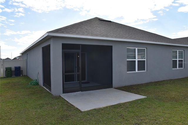 back of house with a lawn, a patio area, and a sunroom