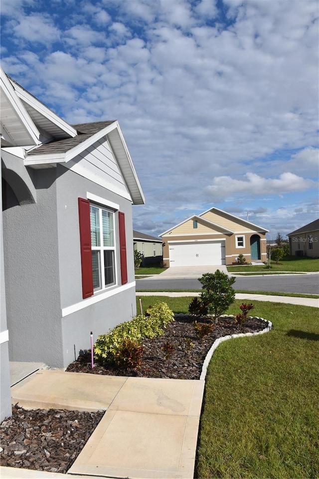 view of home's exterior with a garage and a lawn