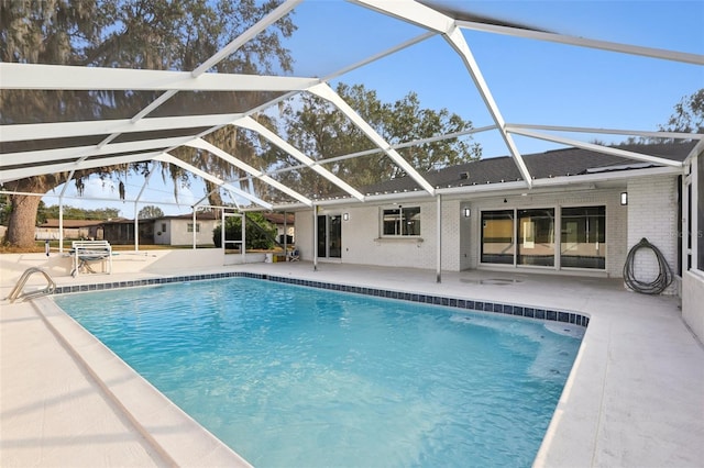 view of pool with glass enclosure and a patio area