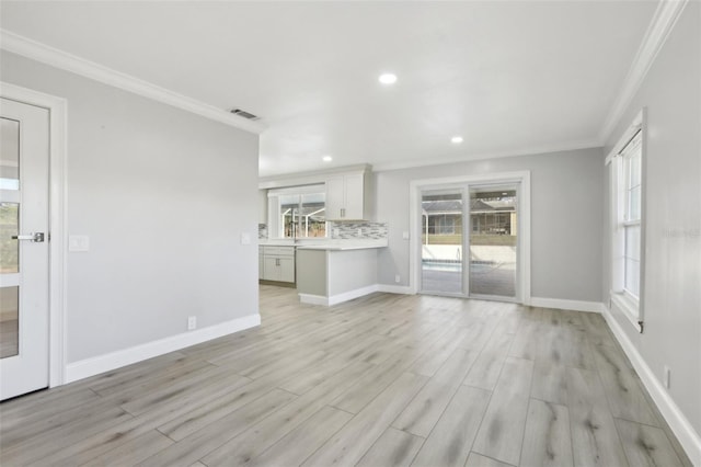 unfurnished living room featuring light hardwood / wood-style floors and ornamental molding