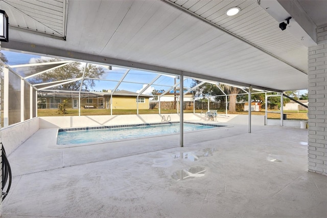 view of swimming pool featuring a patio area and a lanai