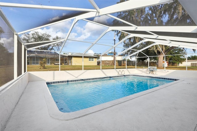 view of swimming pool featuring a patio area and a lanai