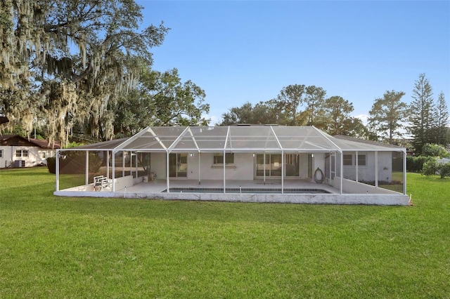 rear view of house featuring a patio area, a lanai, and a lawn