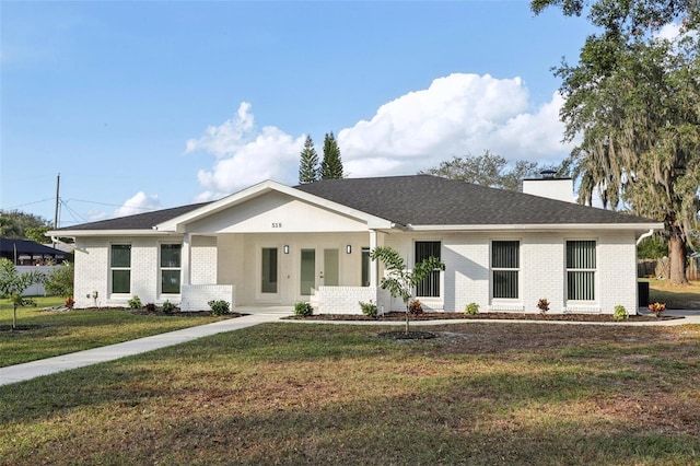 ranch-style home featuring covered porch and a front lawn