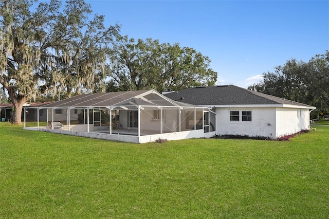 back of property with a yard and glass enclosure