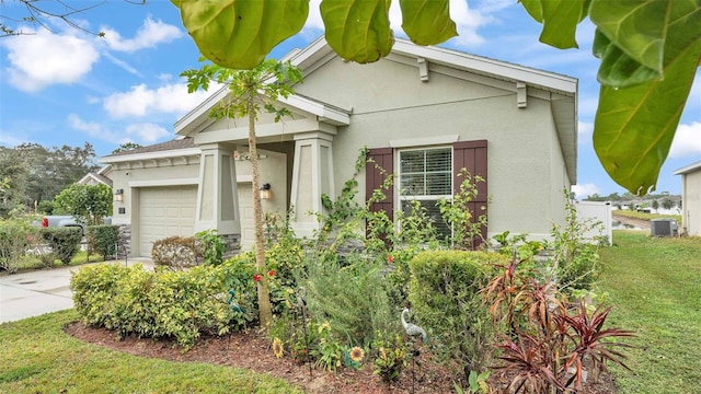 view of front of property featuring cooling unit, a front lawn, and a garage