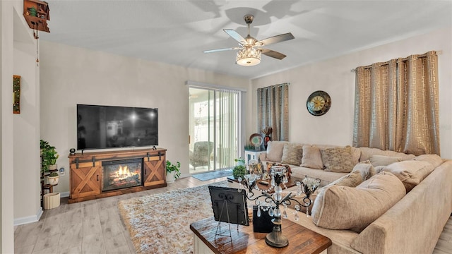 living room featuring ceiling fan and light hardwood / wood-style floors