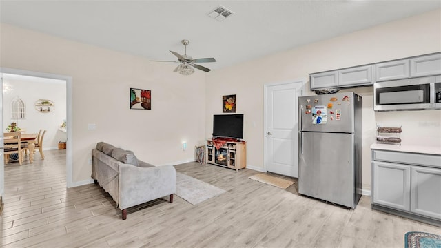 living room with light wood-type flooring and ceiling fan