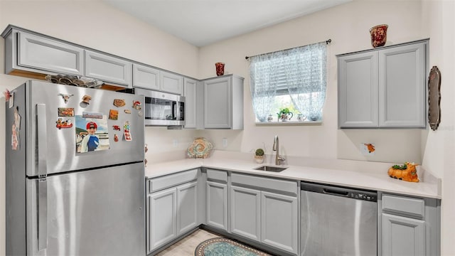 kitchen featuring gray cabinets, sink, and stainless steel appliances