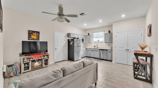 living room featuring ceiling fan and sink