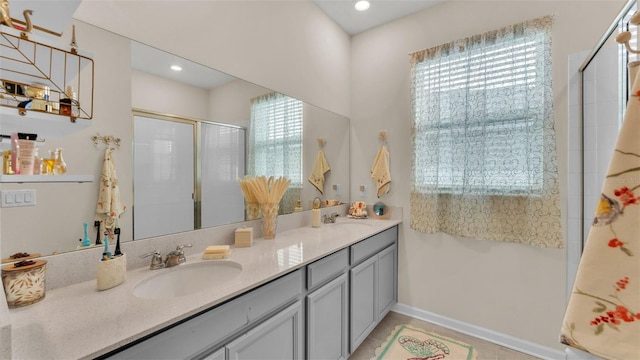 bathroom featuring vanity, a healthy amount of sunlight, and a shower with door