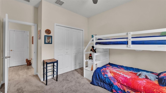 bedroom with a closet, ceiling fan, and light colored carpet